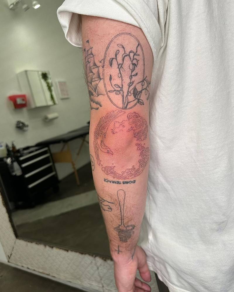 Fine line eagle and smoke tattoo located on the elbow.