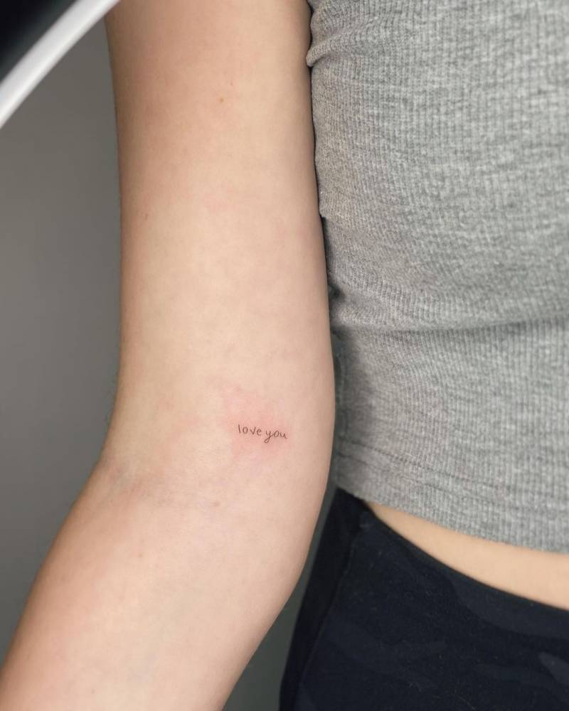 "Love you" lettering tattoo located on the inner arm.