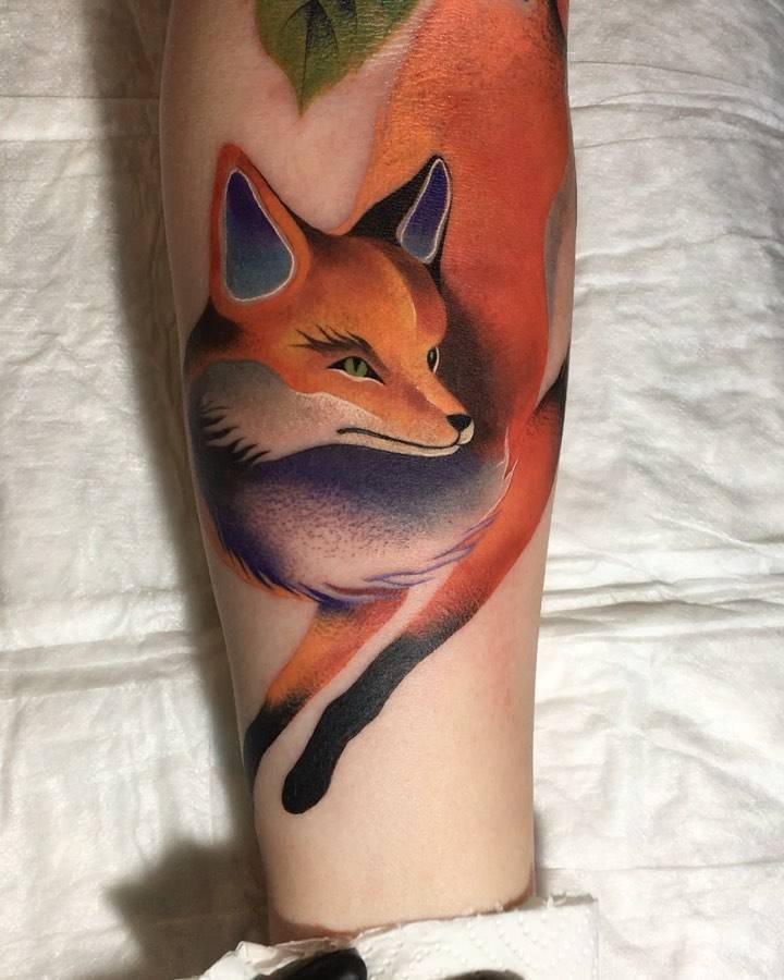 Watercolor style fox tattoo located on the inner forearm.