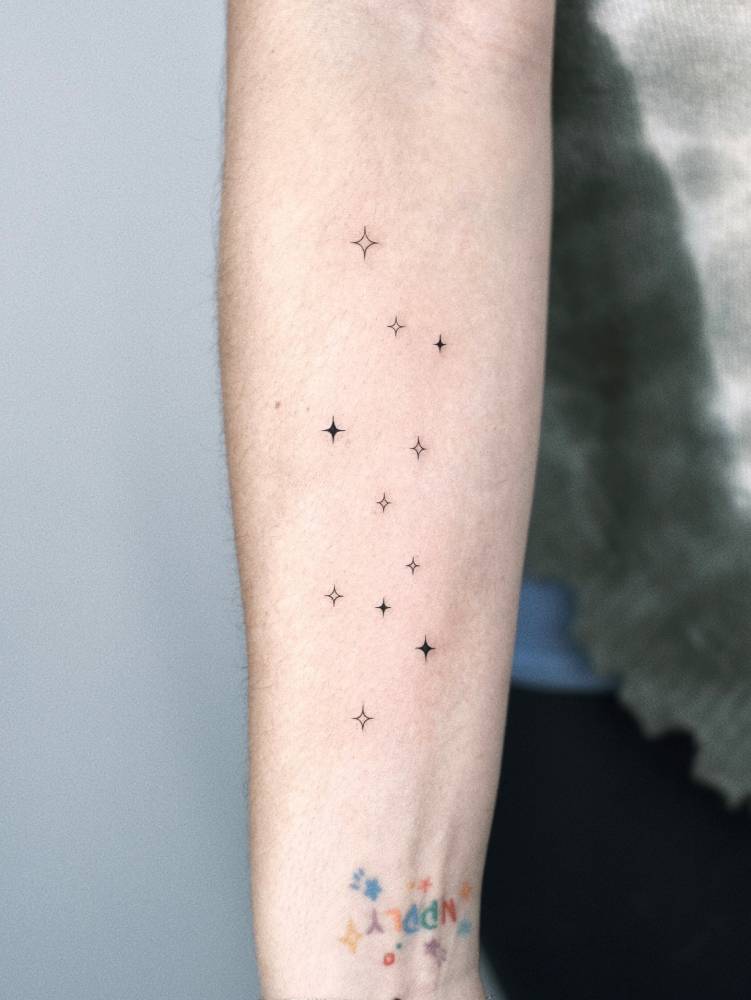 Star collection tattoo located on the inner forearm, minimalistic style.