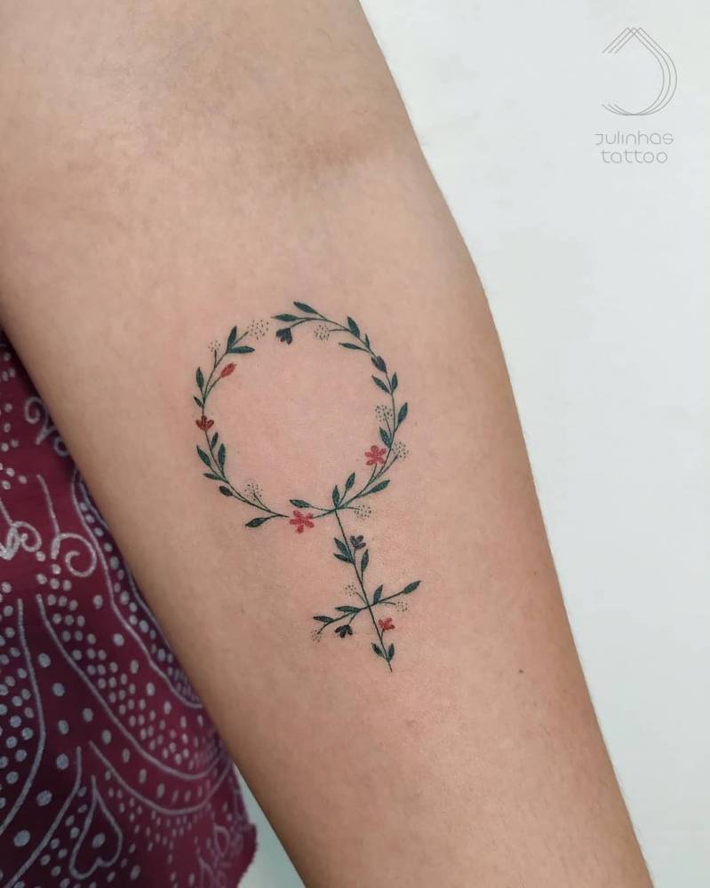 Floral venus symbol tattoo done on the inner forearm.