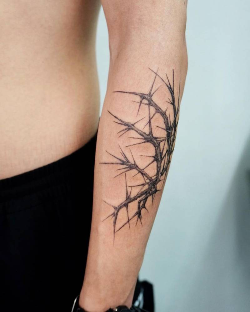 Micro-realistic thorn tattoo located on the forearm.