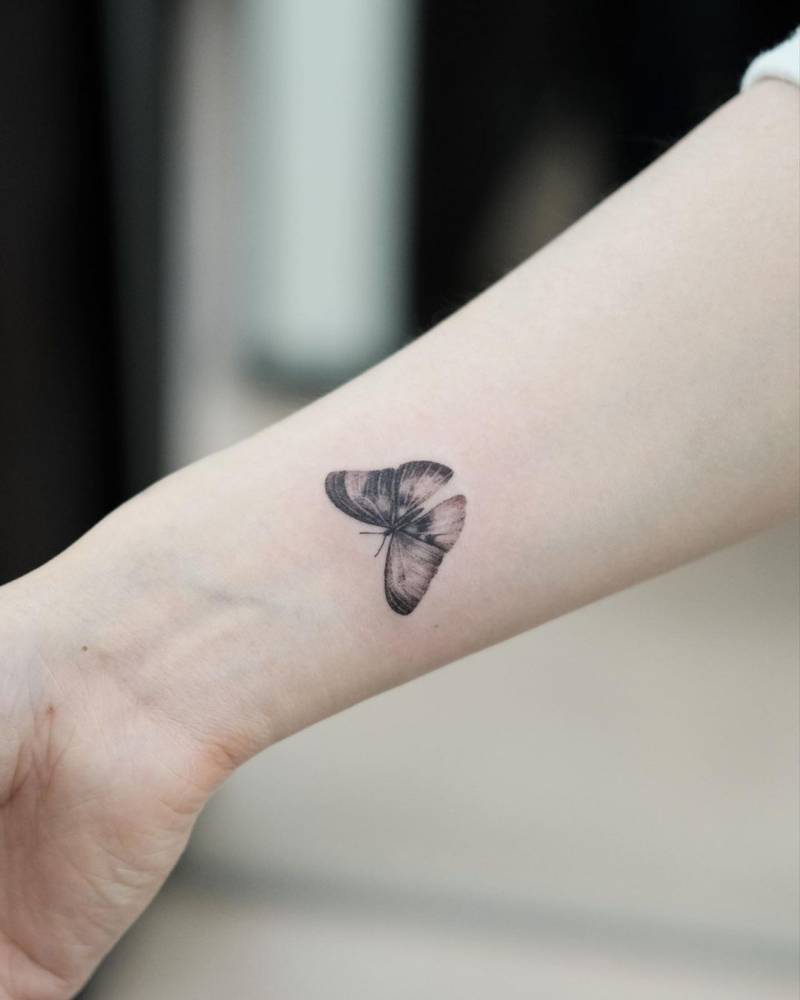 Micro-realistic butterfly tattoo located on the wrist.