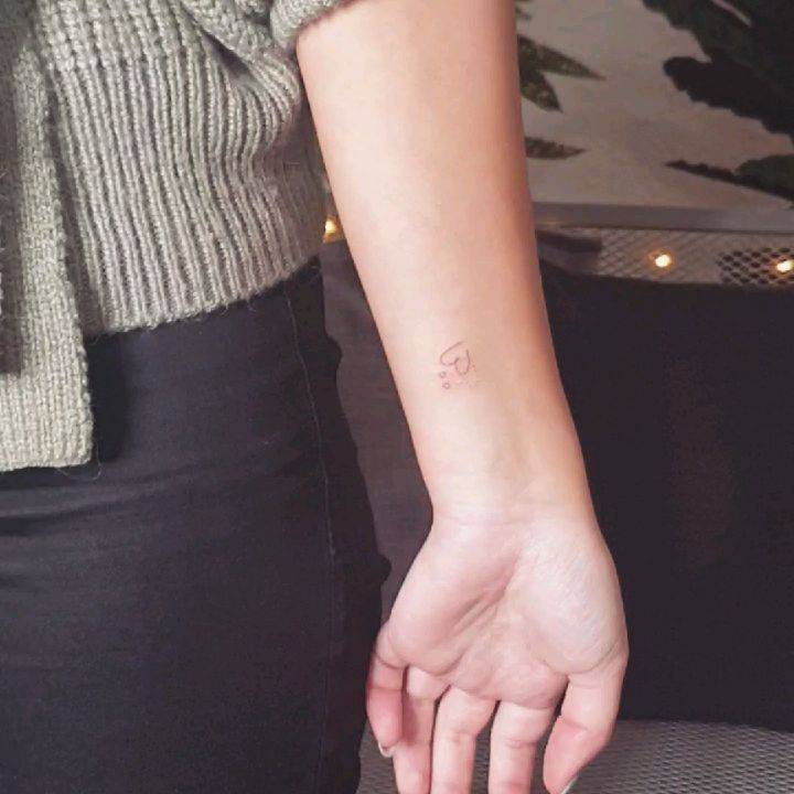 Minimalist heart tattoo on the wrist.