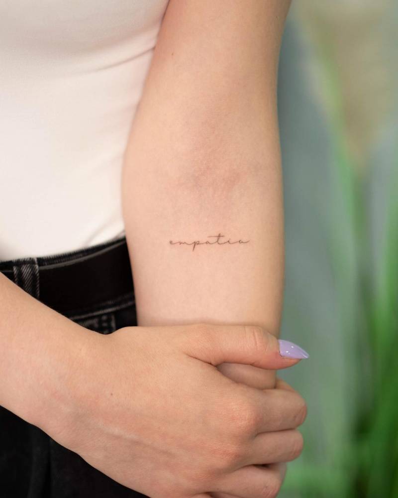 "Empatía" lettering tattoo on the inner forearm