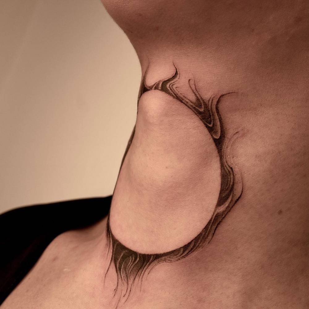Abstract sun tattoo in blackwork style located on the throat.
