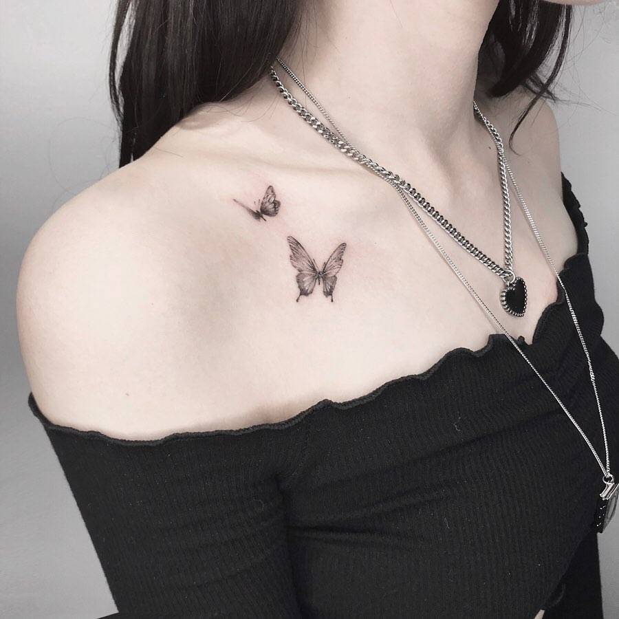 Watercolor style butterfly couple tattoo located on the collarbone.