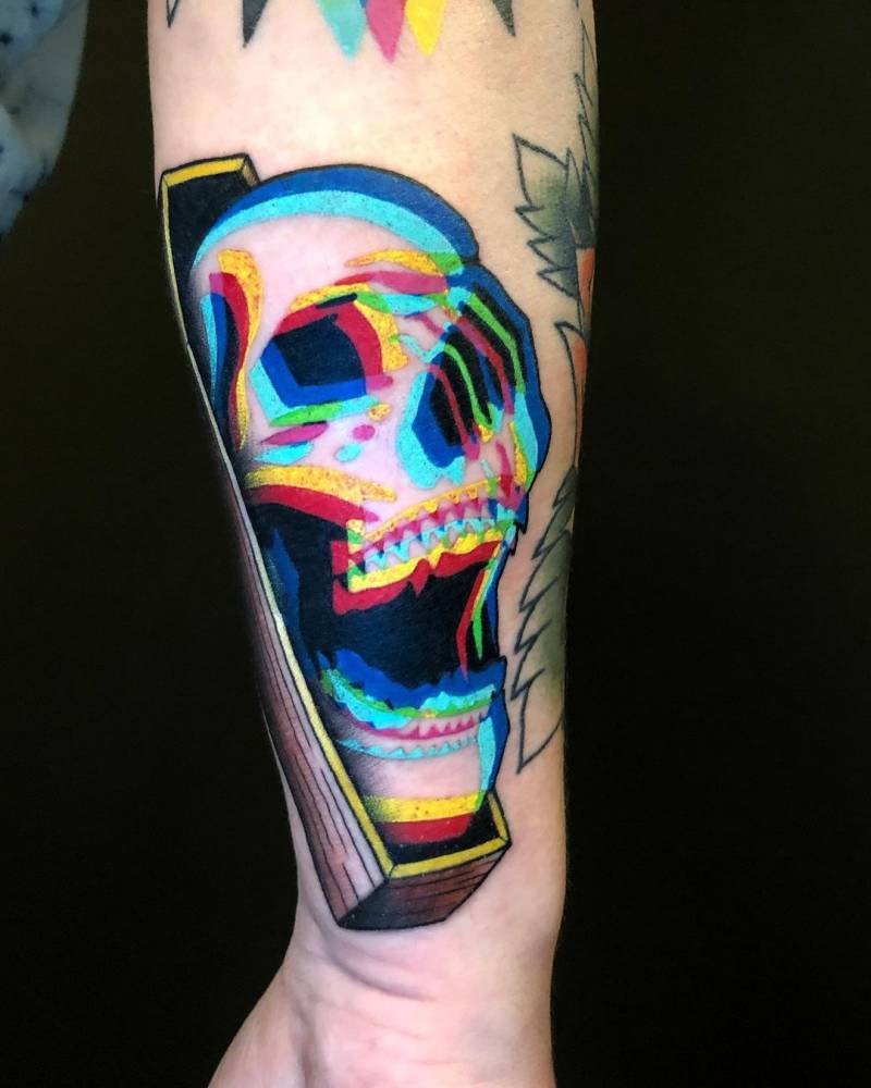 Anaglyph skull in a coffin tattooed on the forearm