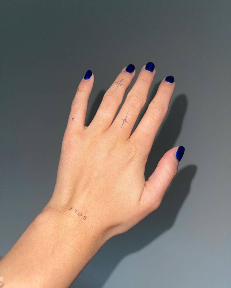 Single needle stars, "sole" and letter "A" tattooed on the fingers