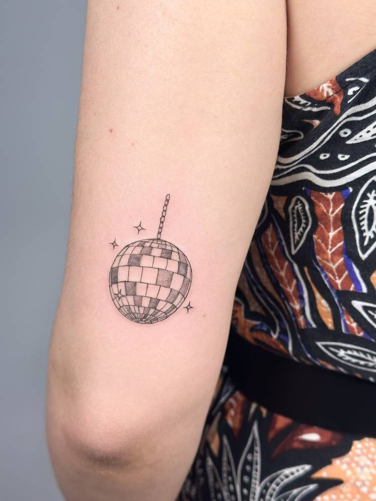 Illustrative style disco ball tattoo done on the tricep.