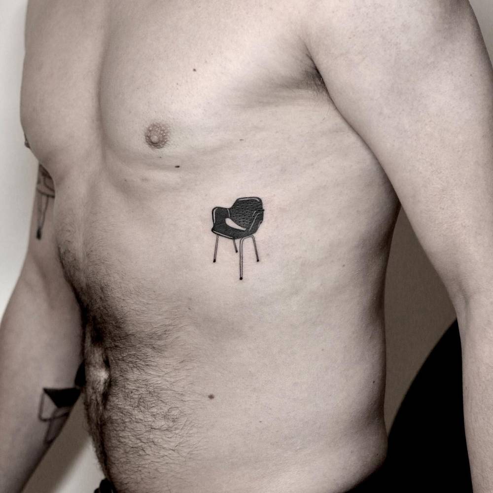 Blackwork style chair tattoo located on the rib.