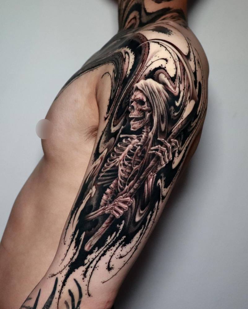 Black and grey Grim Reaper tattoo located on the upper arm.