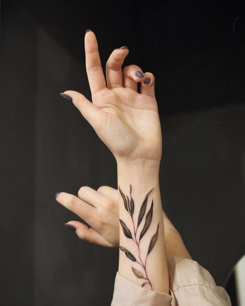 Watercolor leaves tattoo on the inner forearm