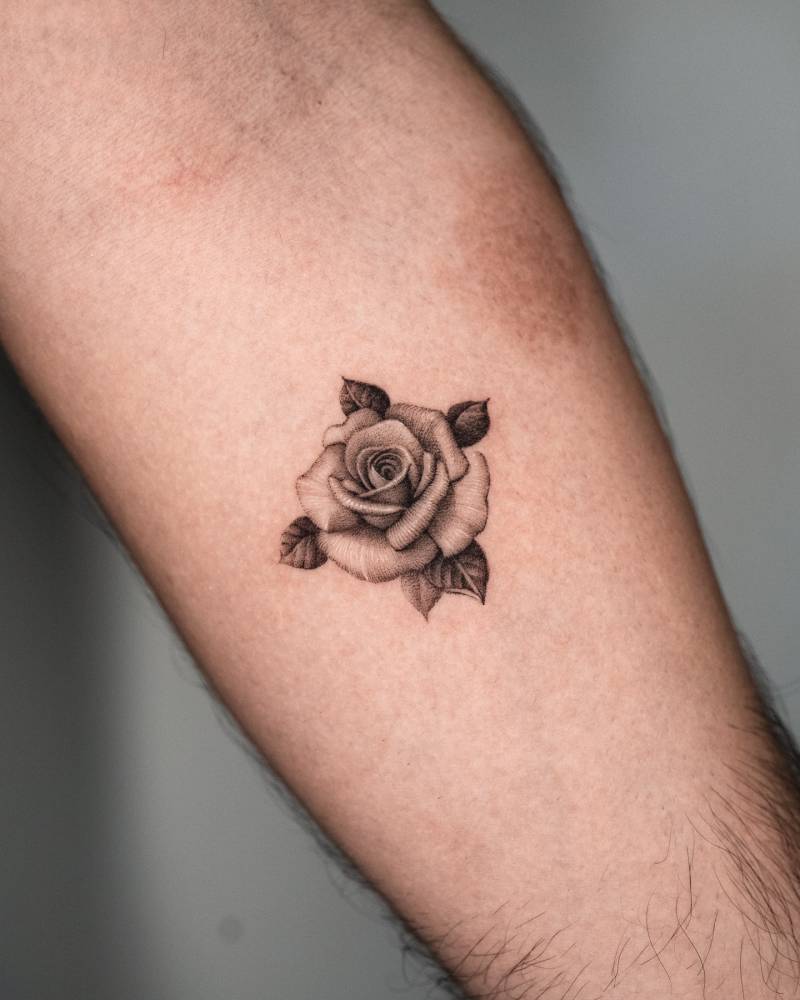 Rose head tattoo in micro-realistic style done on the inner forearm.