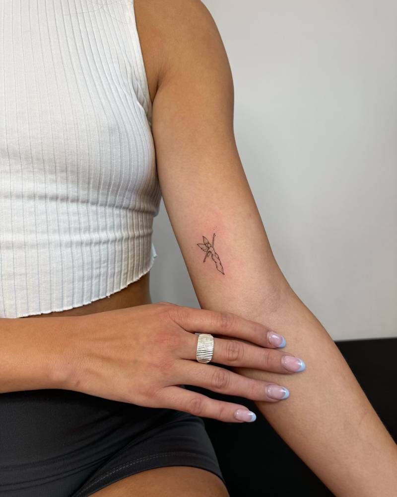 Fine line style fairy tattoo located on the inner arm.