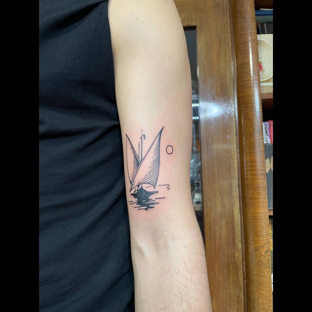 Blackwork style sailboat tattoo located on the bicep.