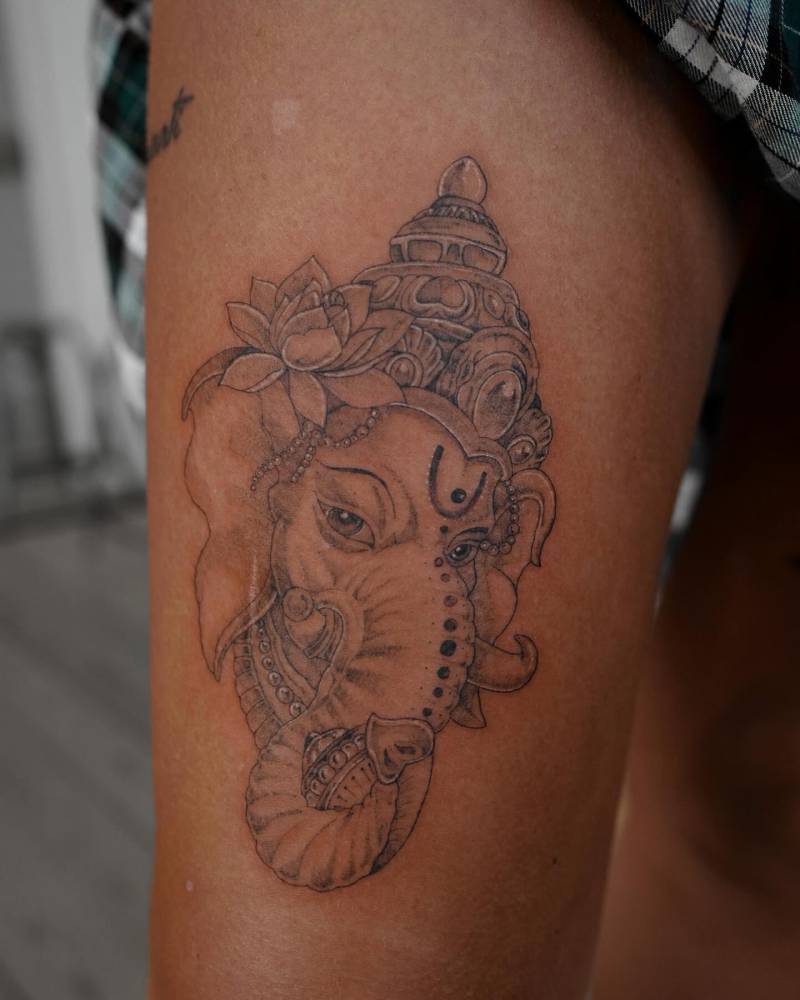 Ganesha tattoo located on the thigh, done in illustrative style.