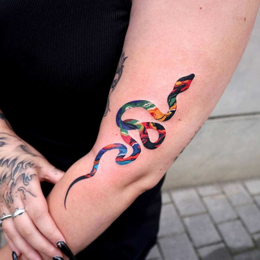 Snake tattoo located on the arm, pop art style.