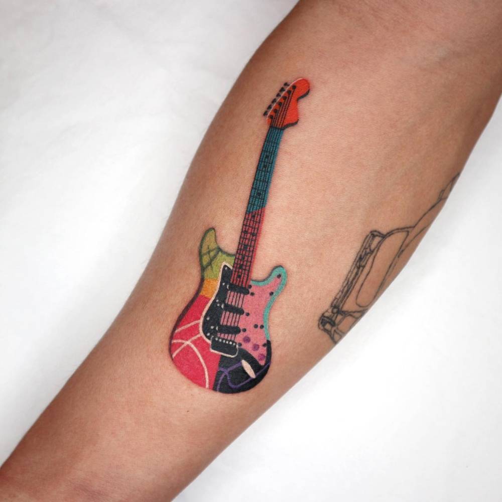 Electric guitar tattooed on the inner forearm, pop art style.
