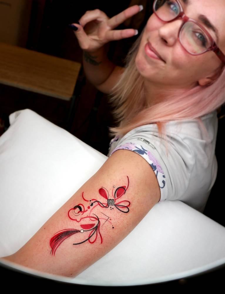 Norigae tattoo in illustrative style placed on the upper arm.