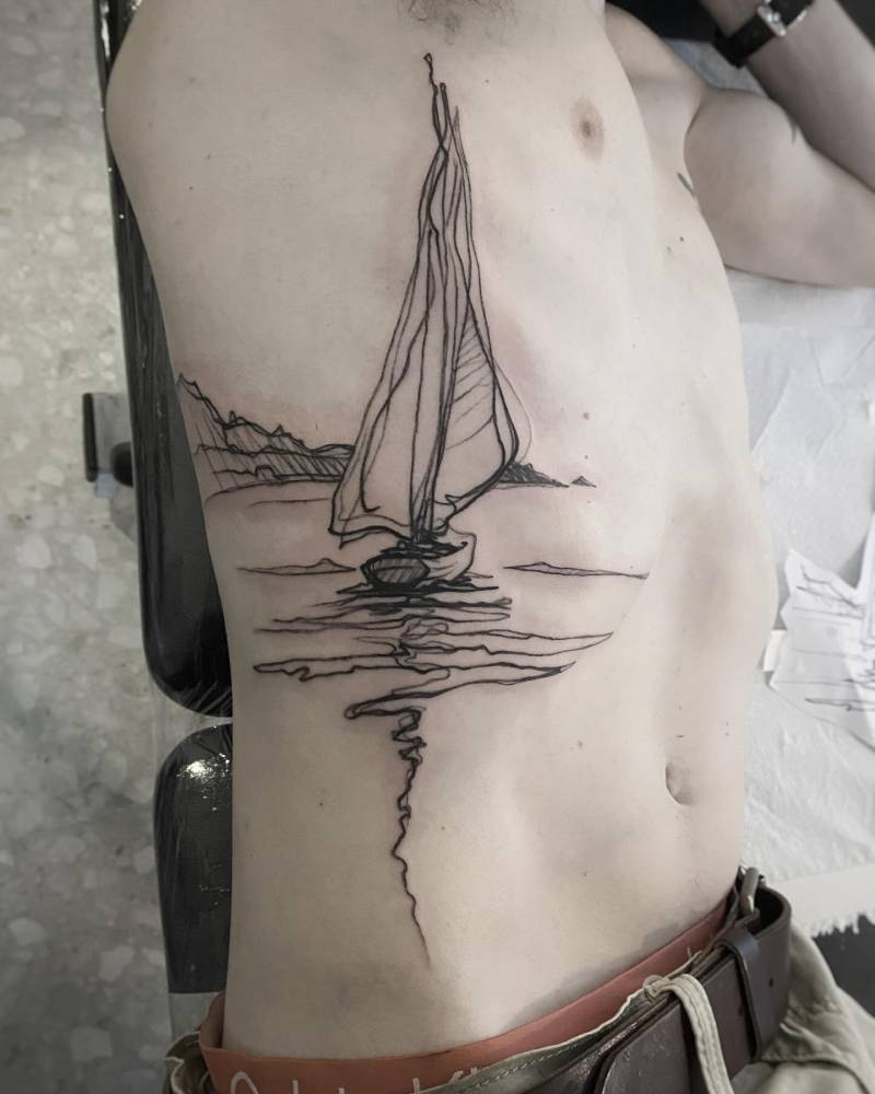 Sketch work style tattoo of a sailboat done on the rib.