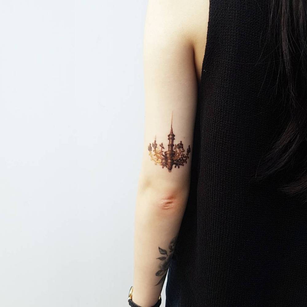 Micro-realistic style chandelier tattooed on the tricep.