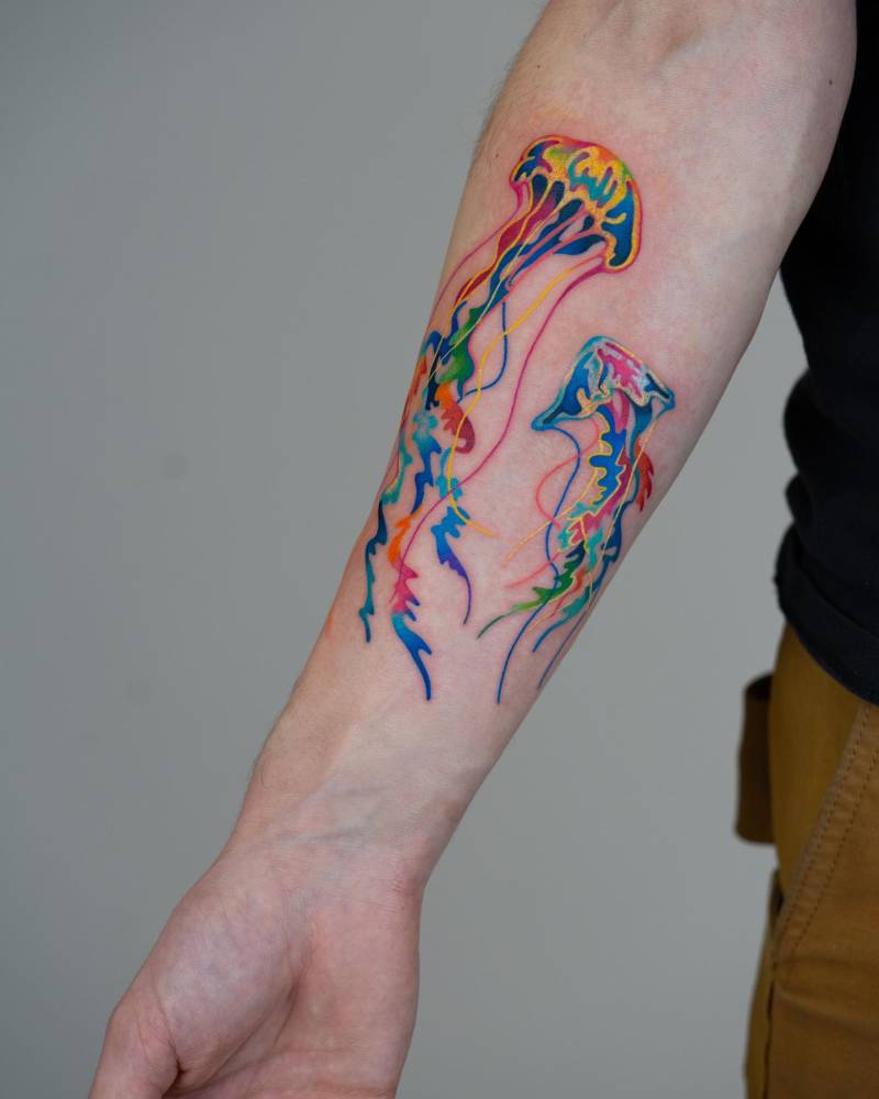 Watercolor style jellyfish tattoo located on the inner forearm.