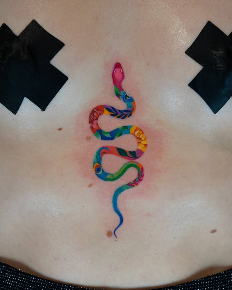 Snake tattoo in illustrative style located on the sternum.