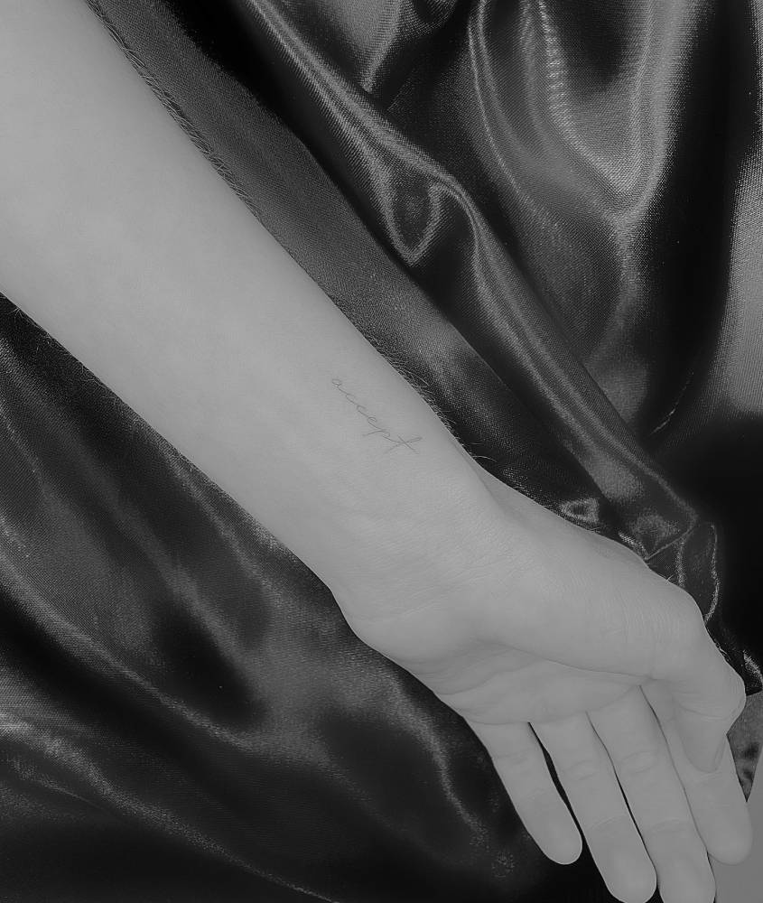 Handwritten lettering tattoo of the word "accept" placed on the wrist.