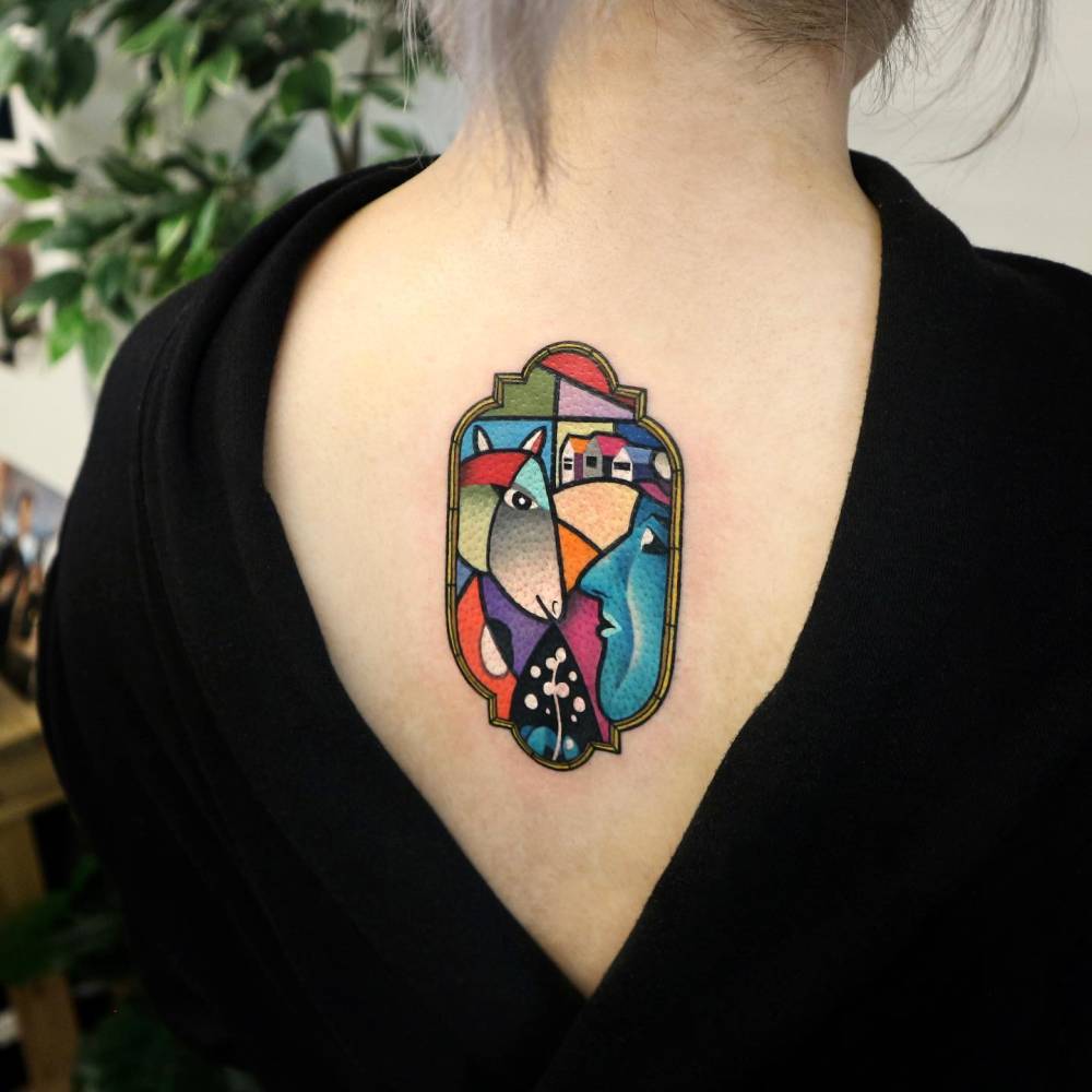 Cubist style abstract tattoo located on the upper back.