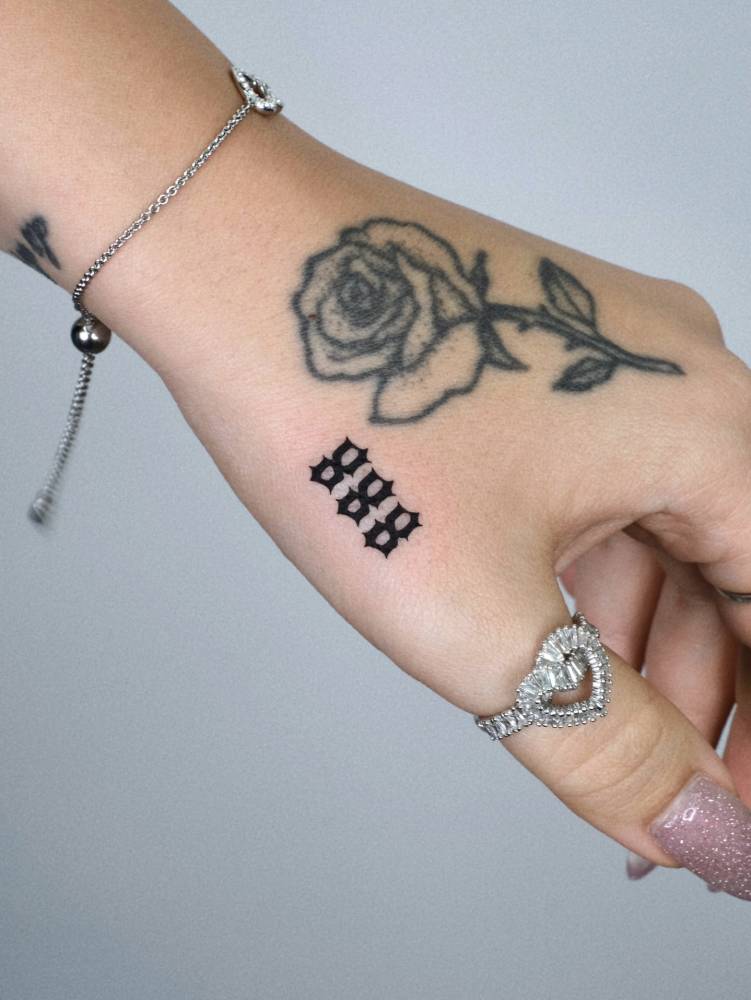 Gothic font angel number "888" tattoo placed on the hand.