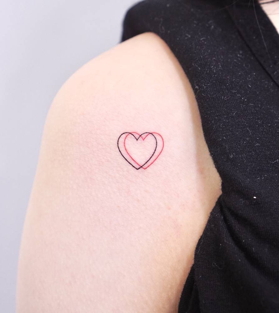 Minimalistic little hearts tattoo placed on the shoulder.