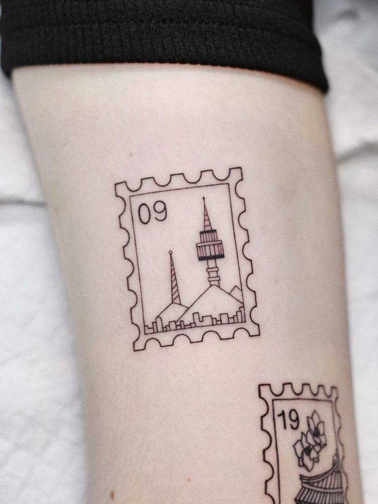 N Seoul Tower stamp tattoo located on the inner arm.