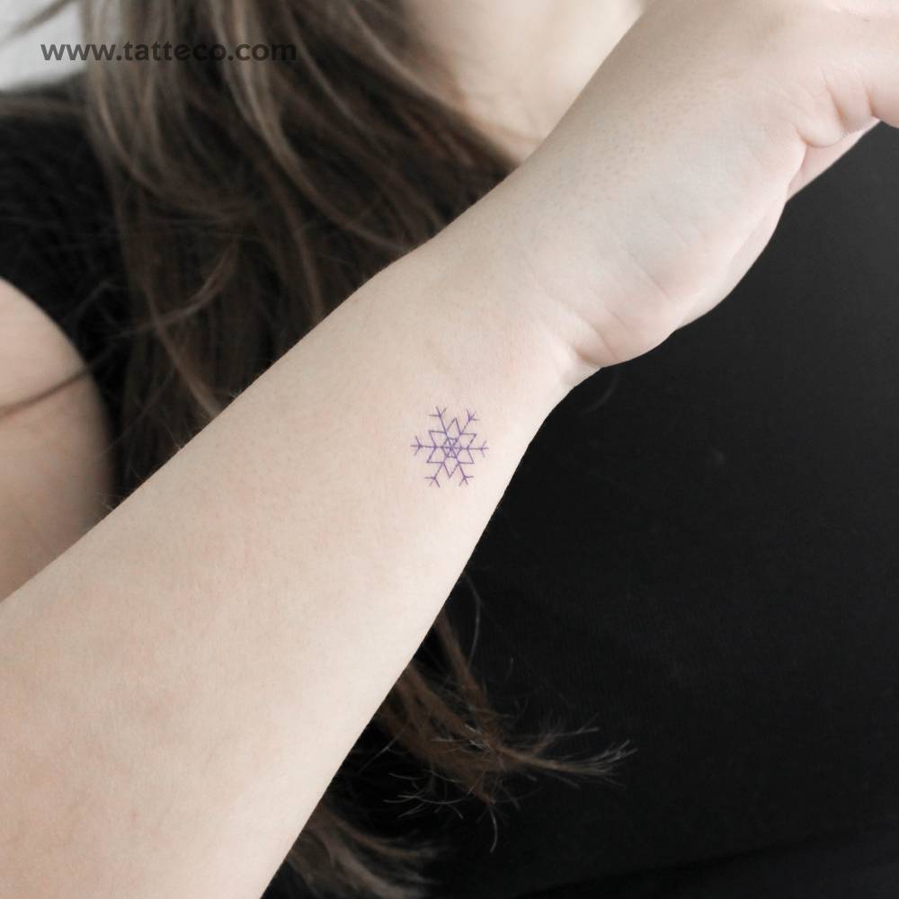 Blue snowflake temporary tattoo located on the wrist.