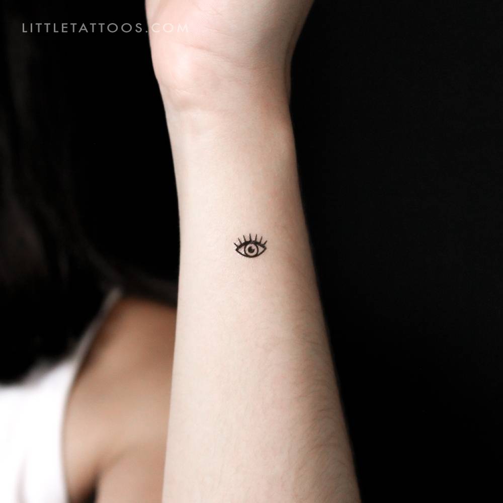 Tiny minimalistic evil eye temporary tattoo located on the wrist.