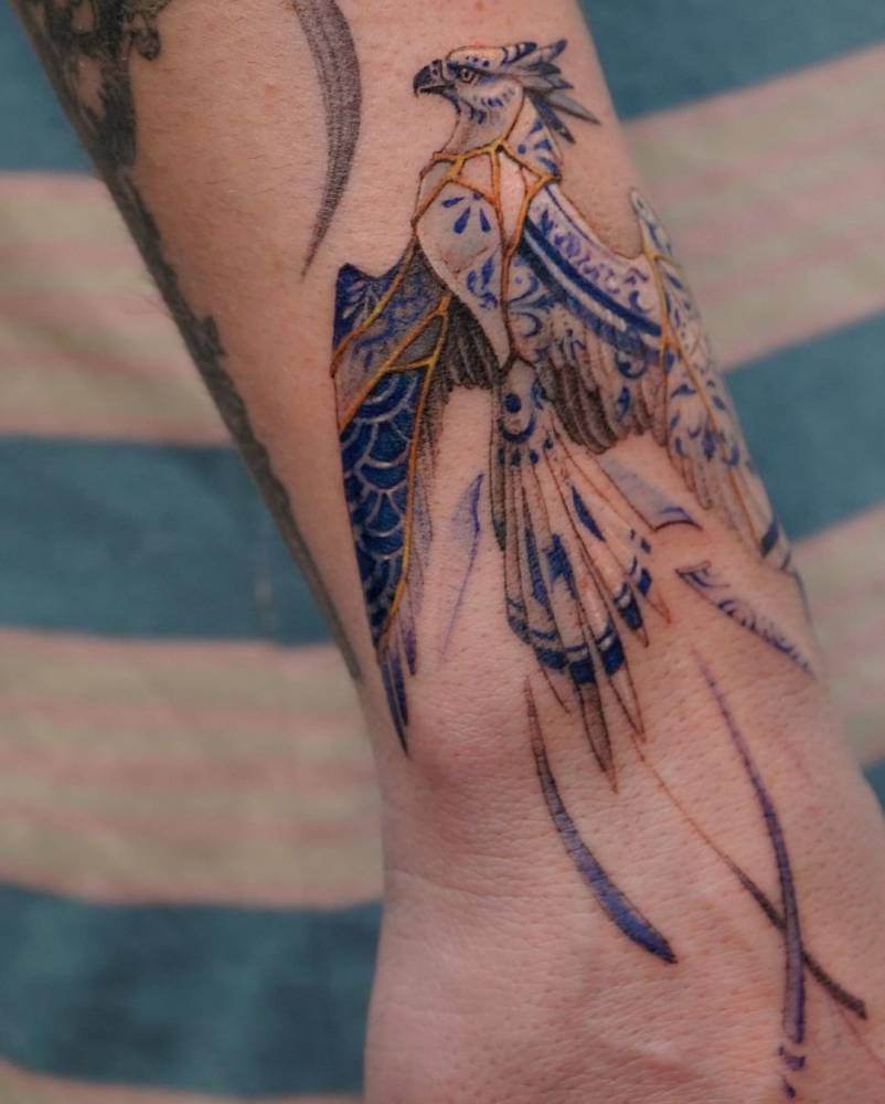 Micro-realistic Phoenix tattoo on the wrist.