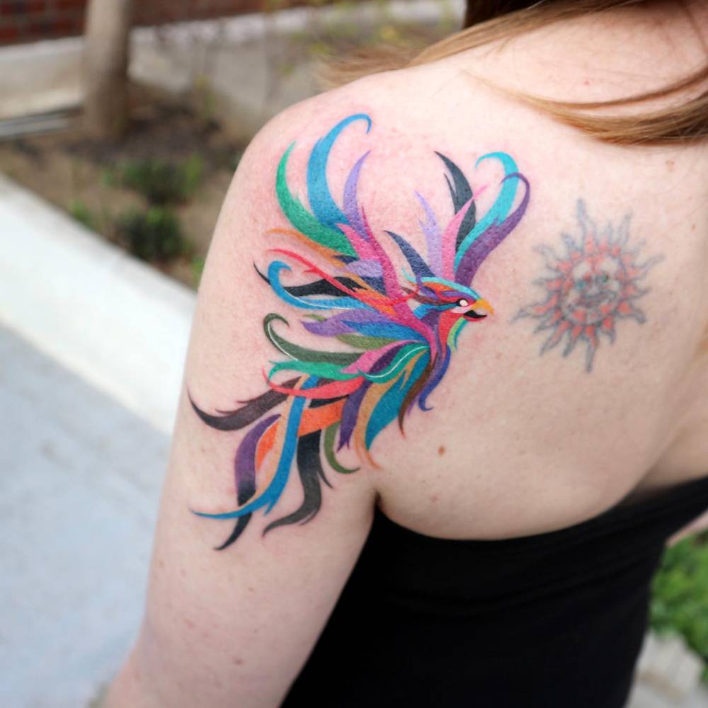 Colorful phoenix tattoo placed on the shoulder blade.