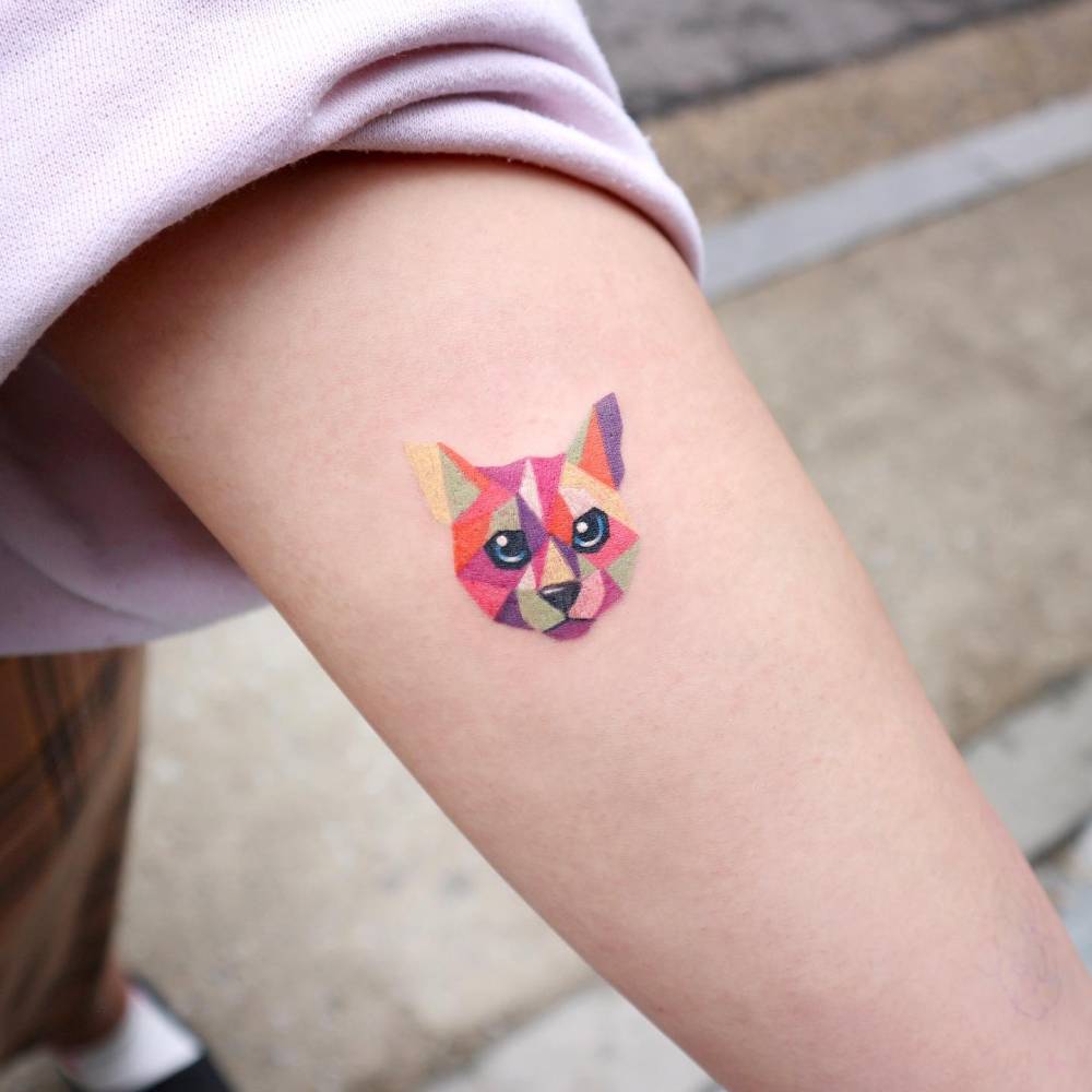 Low poly cat portrait tattoo placed on the inner arm.