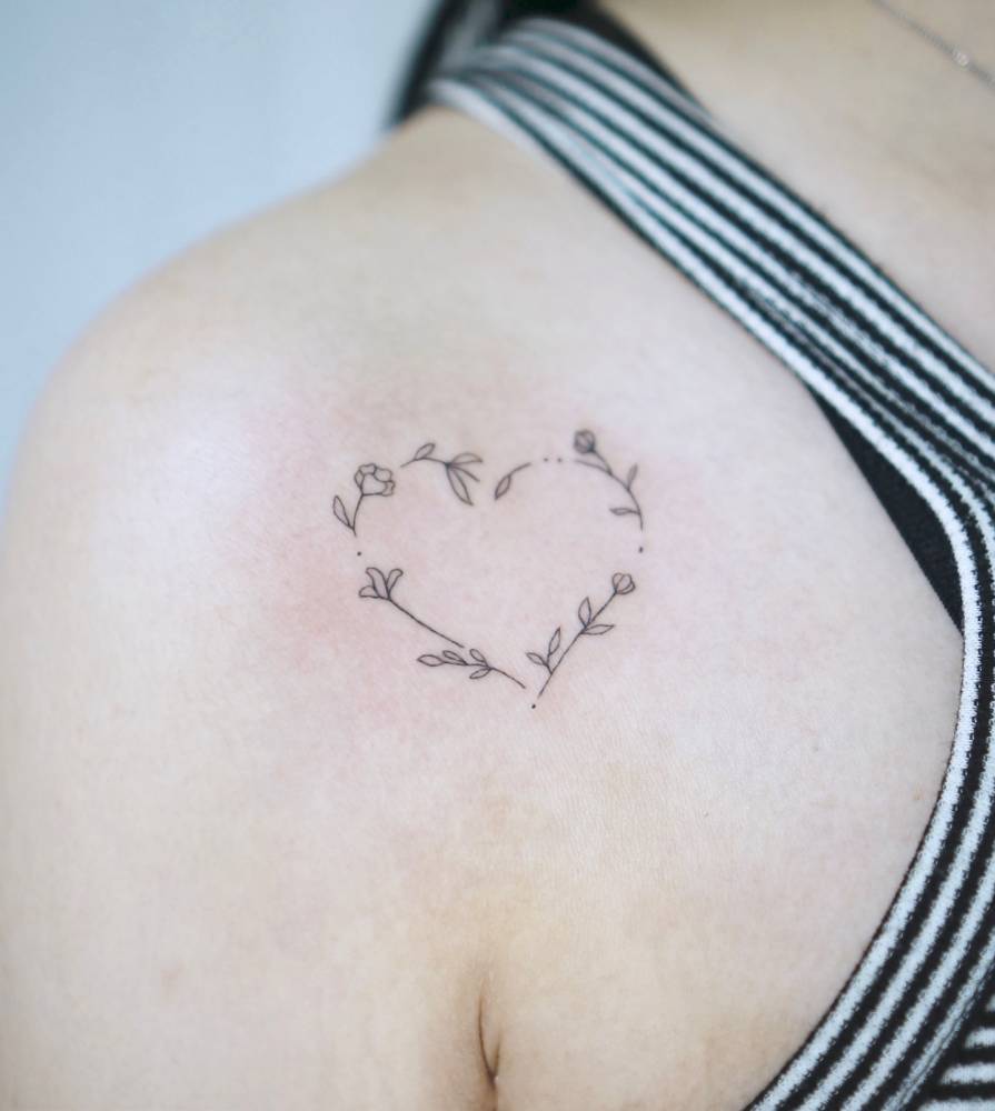 Flower wreath tattoo located on the shoulder, minimalistic style.