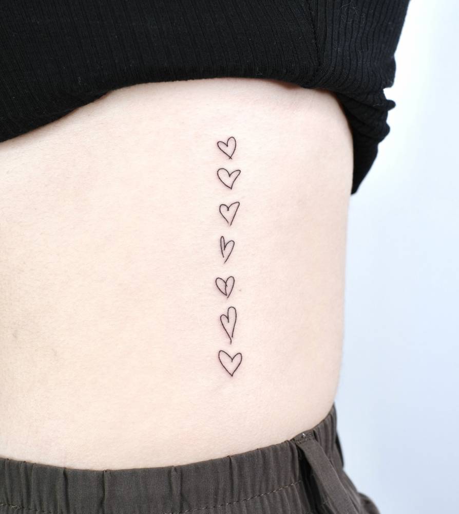 Heart collection tattoo in minimalistic style located on the rib.
