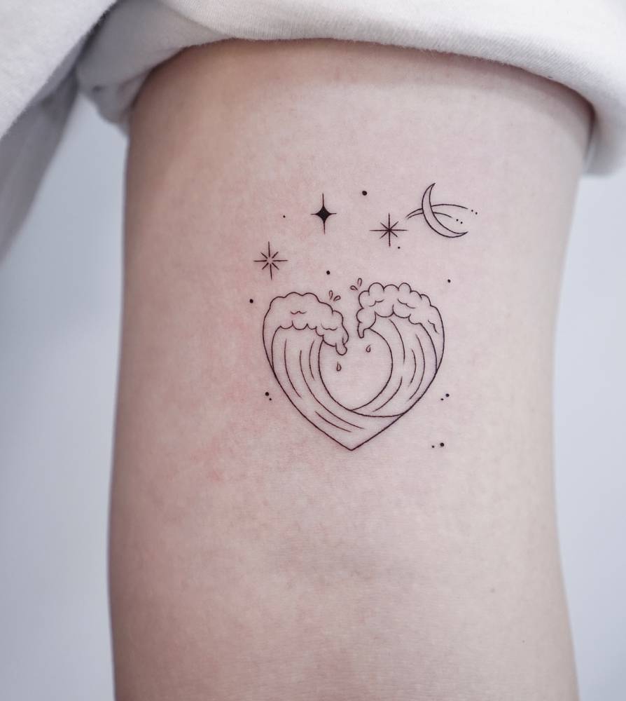 Wave heart, stars and moon tattoo located on the bicep.