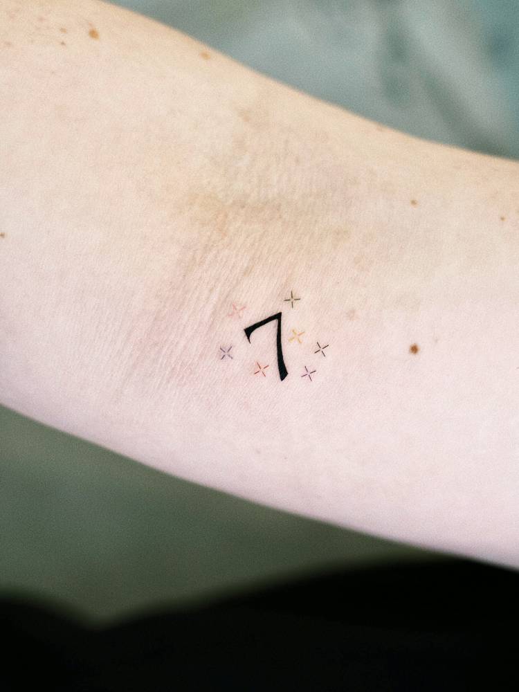 Little tattoo of the number "7" located on the inner forearm.
