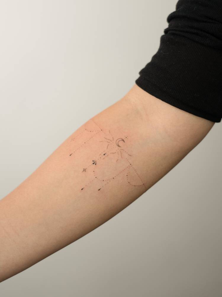 Ornamental bracelet tattooed on the inner forearm, fine line style.