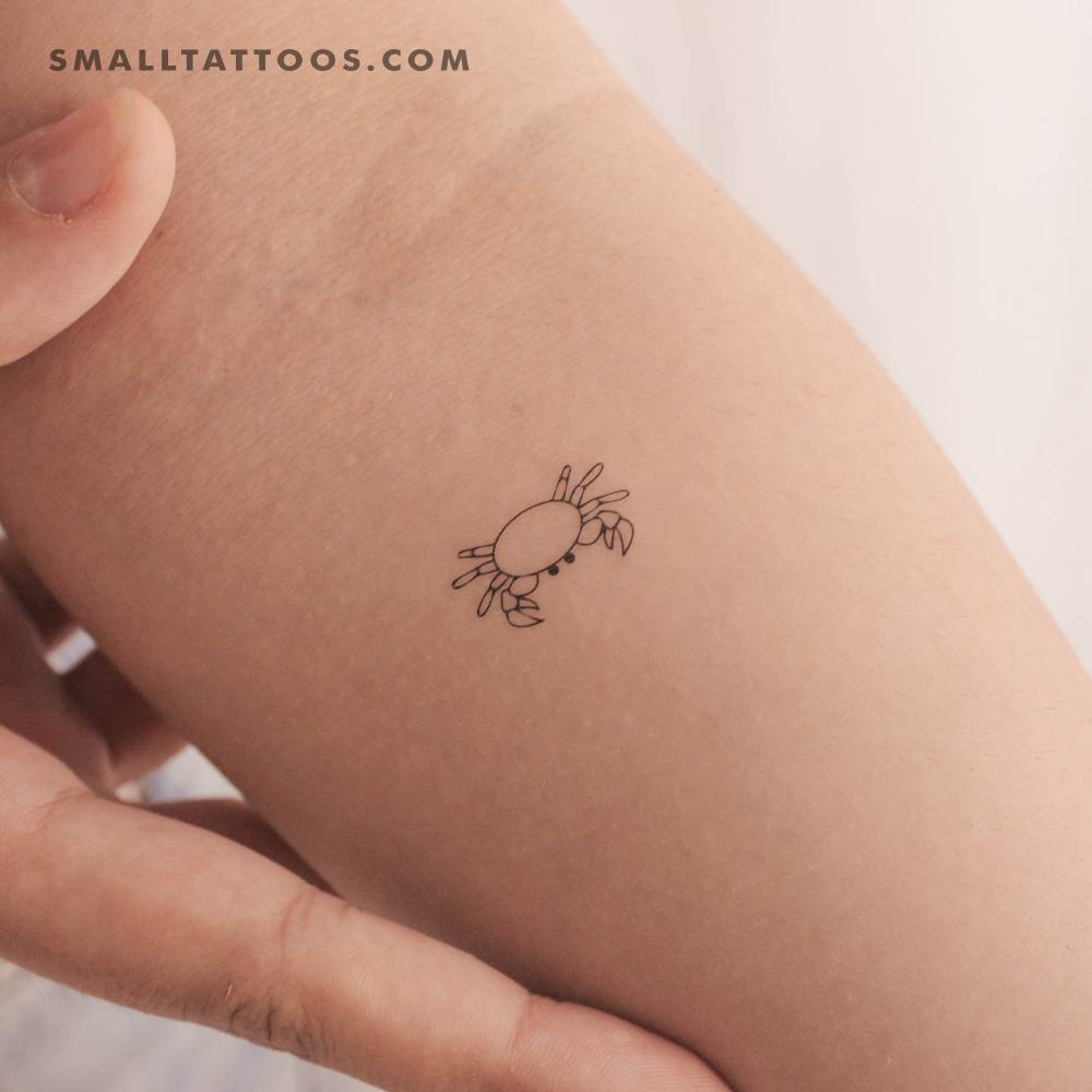 Fine line style little crab temporary tattoo located on the inner forearm.