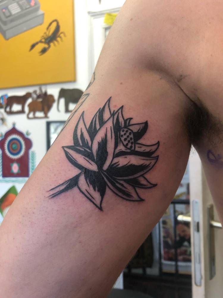 Lotus flower tattoo in blackwork style done on the inner arm.