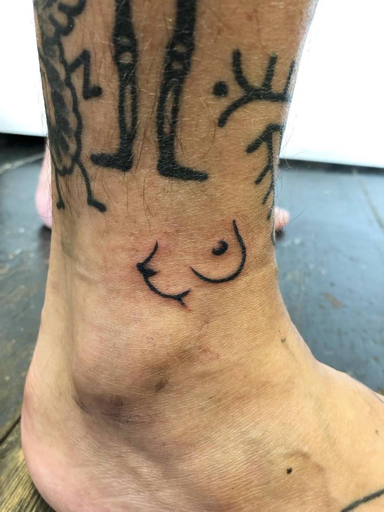 Boobs tattoo in minimalistic style located on the ankle.