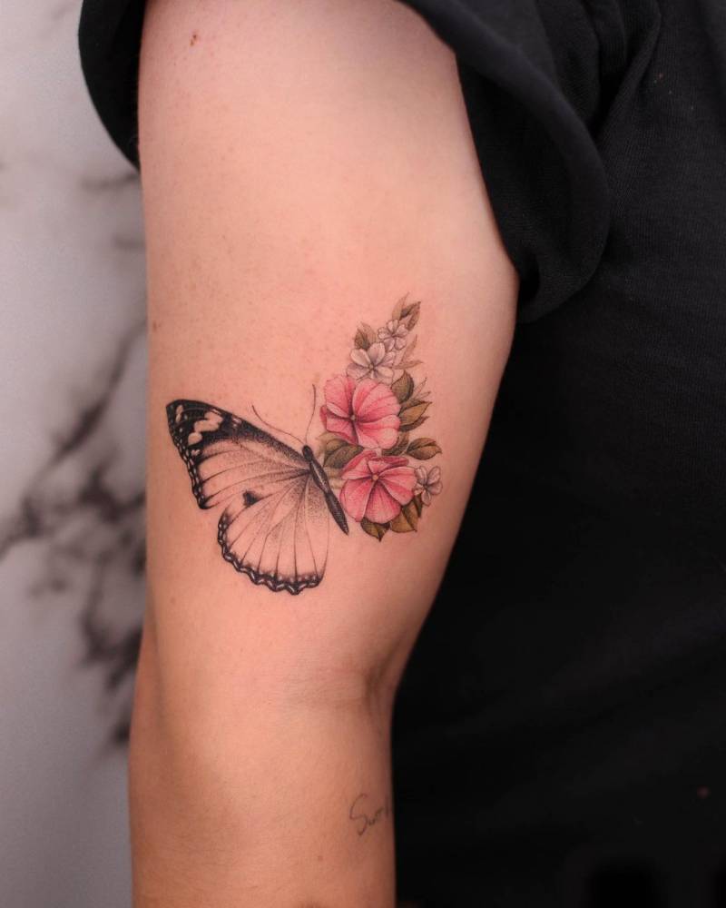 Micro-realistic style half butterfly half flowers tattoo located on the upper arm.