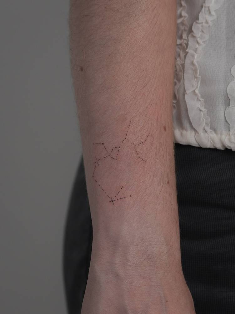 Sagittarius constellation tattoo located on the wrist.