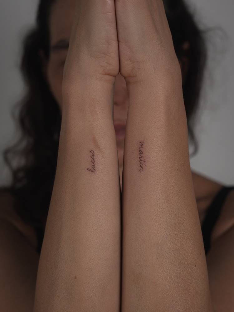 Names "Lucas" and "Martin" in handwritten font tattooed on the wrist.