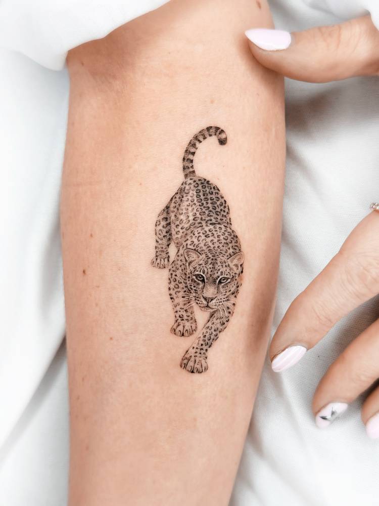 Leopard tattoo located on the inner forearm, micro-realistic style.